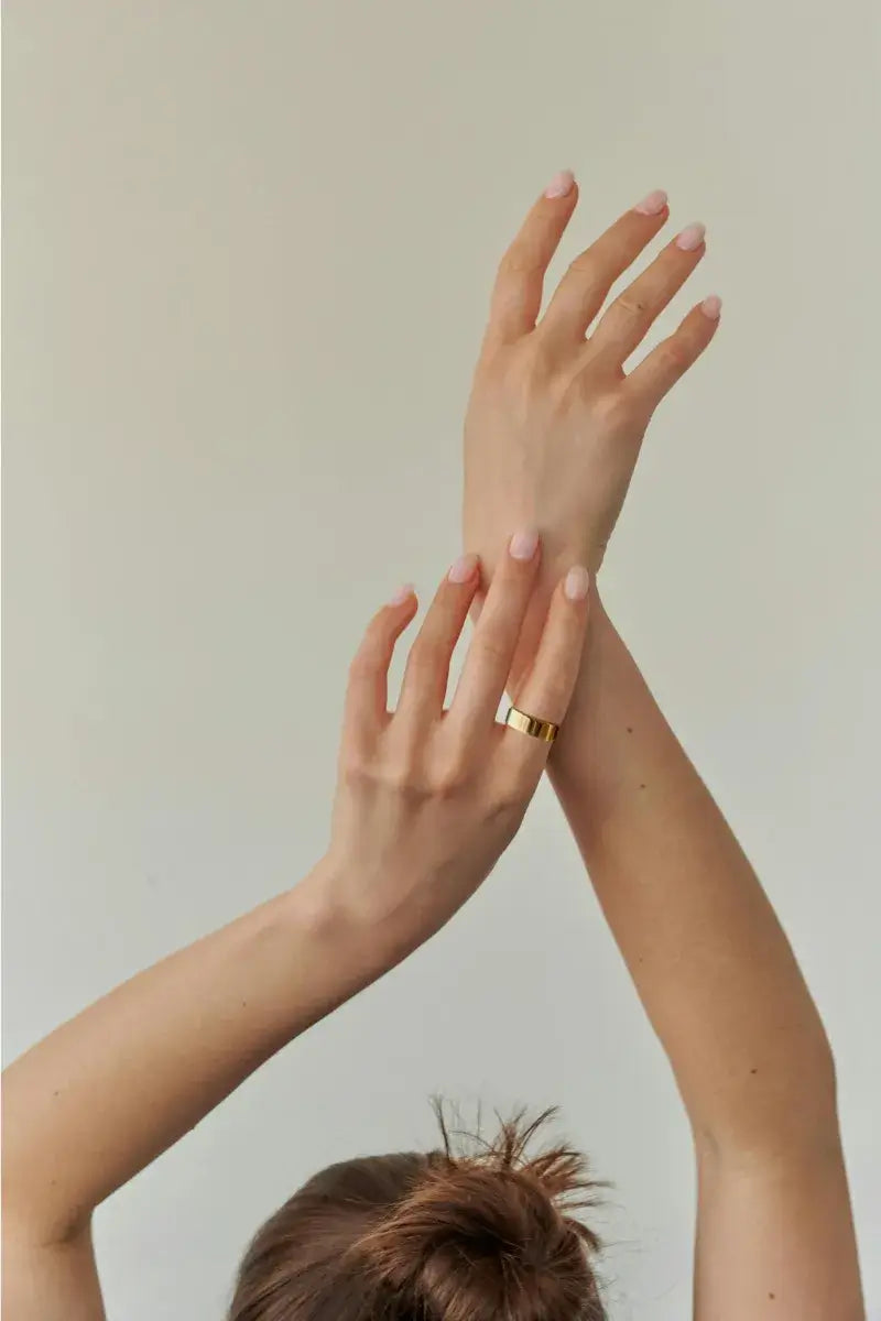 a dancer wearing jupitercore air smart ring lifting her hands showcase the ring is sleek and move with you