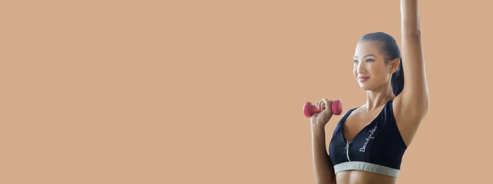 Woman exercising with a pink dumbbell, promoting fitness and healthy lifestyle.